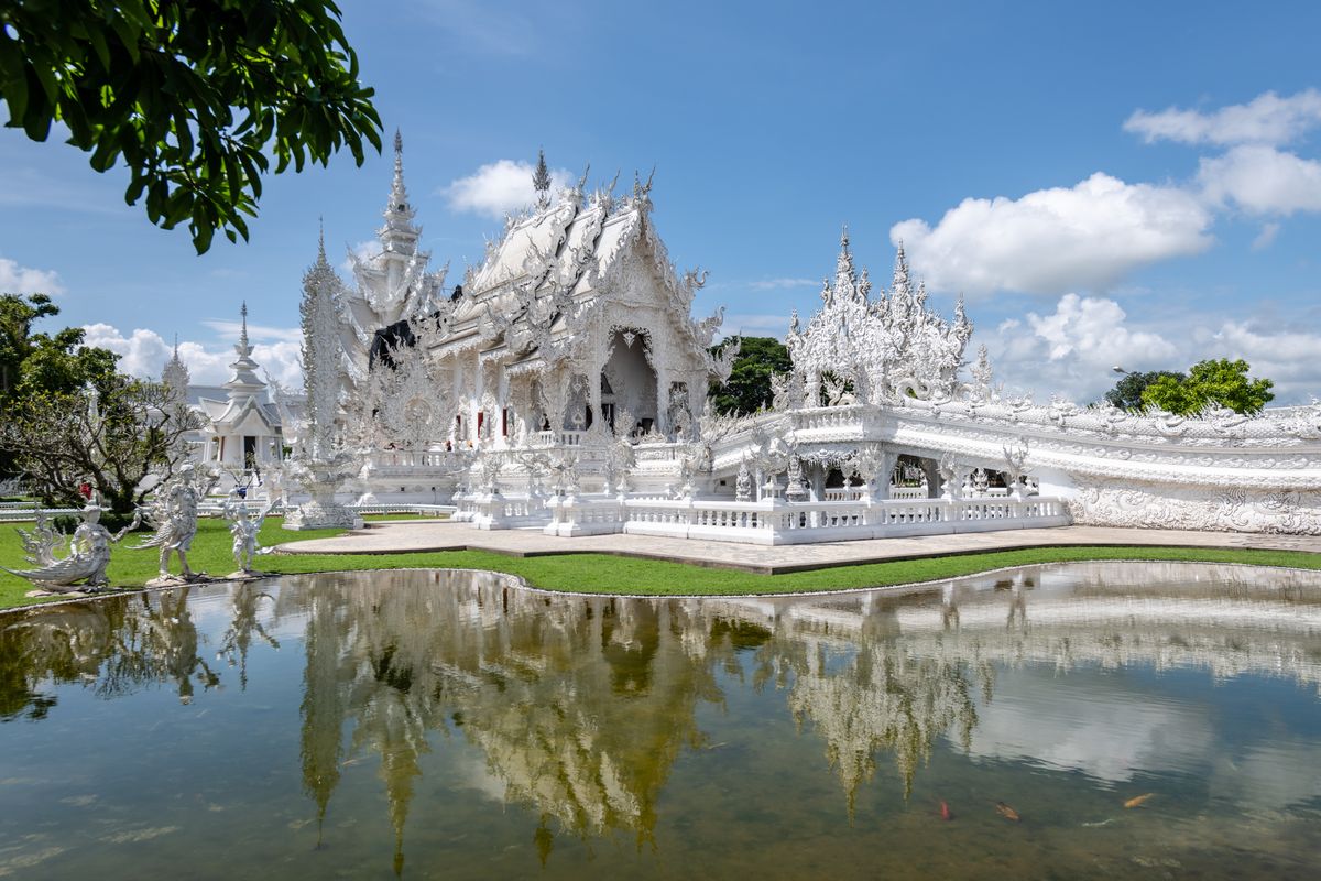 Templo Blanco Wat Rong Khun reflejado en el agua, en Chiang Rai